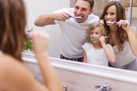 a family brushing teeth together