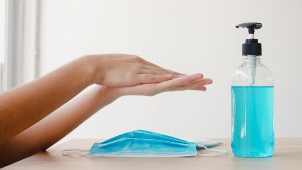 a girl rubs her hand with sanitizer